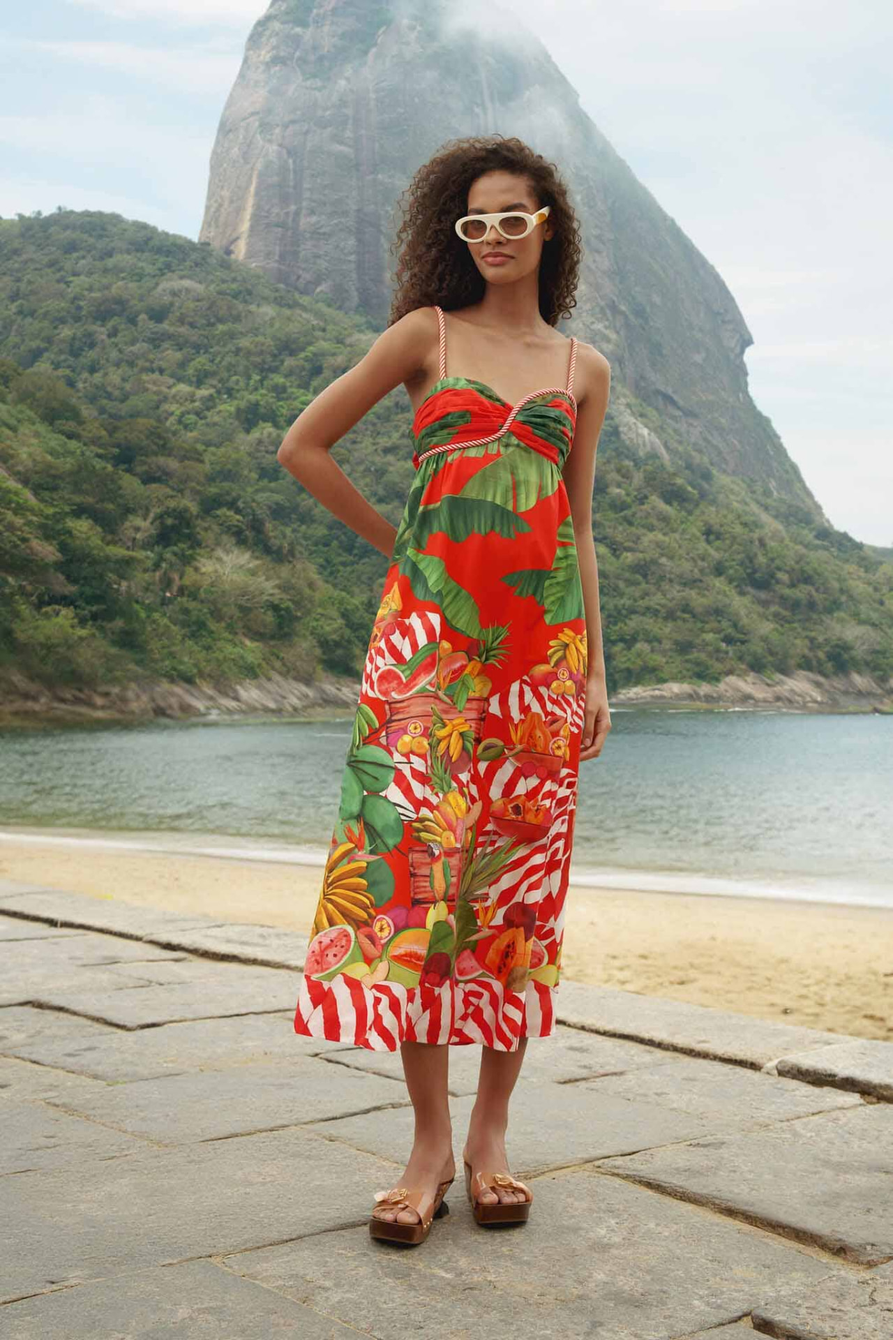 Model in a red Farm Rio fruit-print sleeveless maxi dress on the Rio waterfront