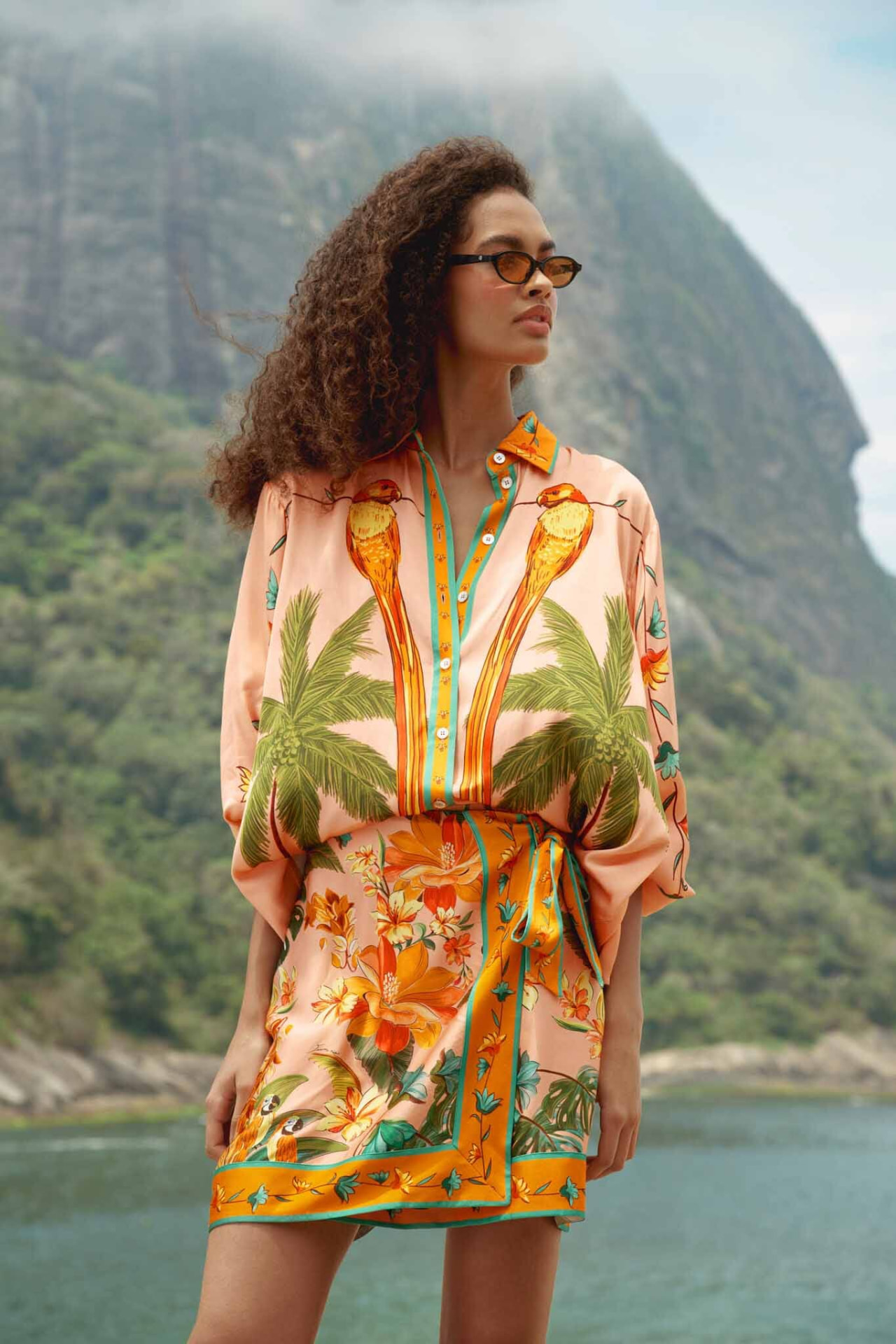 Model in a Farm Rio printed wrap mini skirt and palm-print shirt