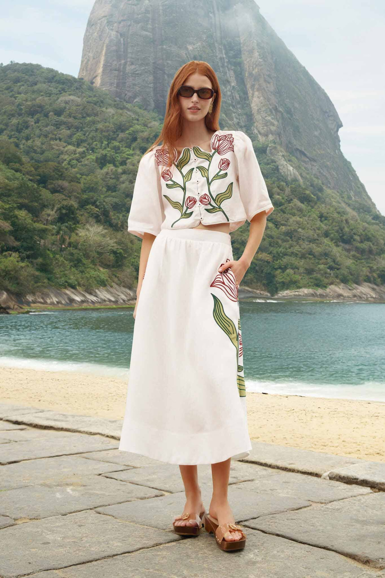 Model in an off-white embroidered linen top and midi skirt by Farm Rio