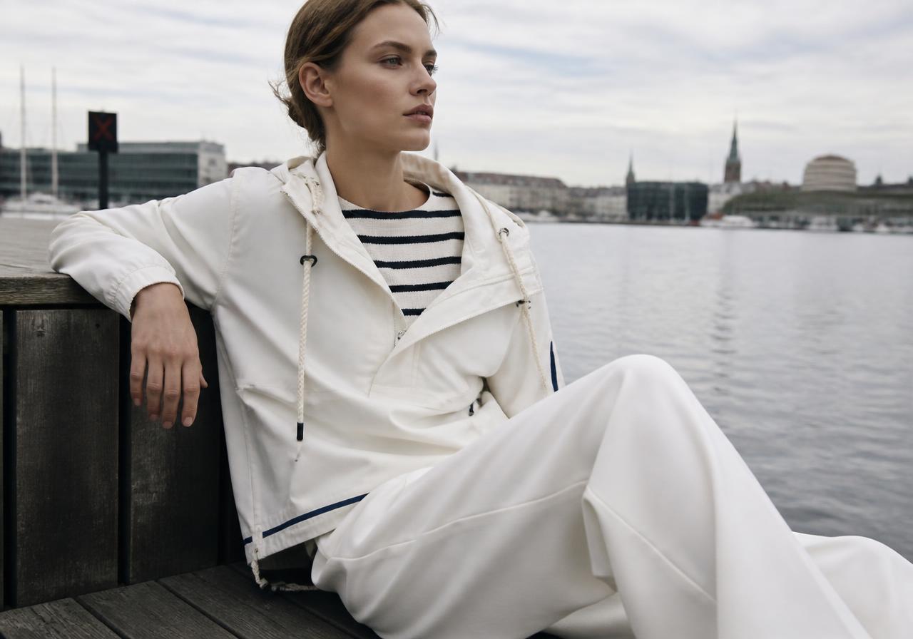 Copenhagen Fashion Week runway trend SS27: navy striped knit with a white technical anorak with rope details and wide trousers by Copenhagen harbour